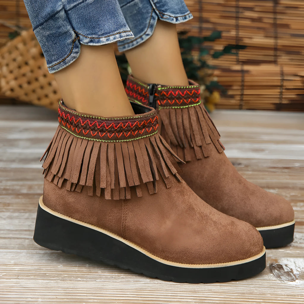 Women's dark brown suede wedge ankle boot with side zipper and tassel detail on a thick rubber sole.