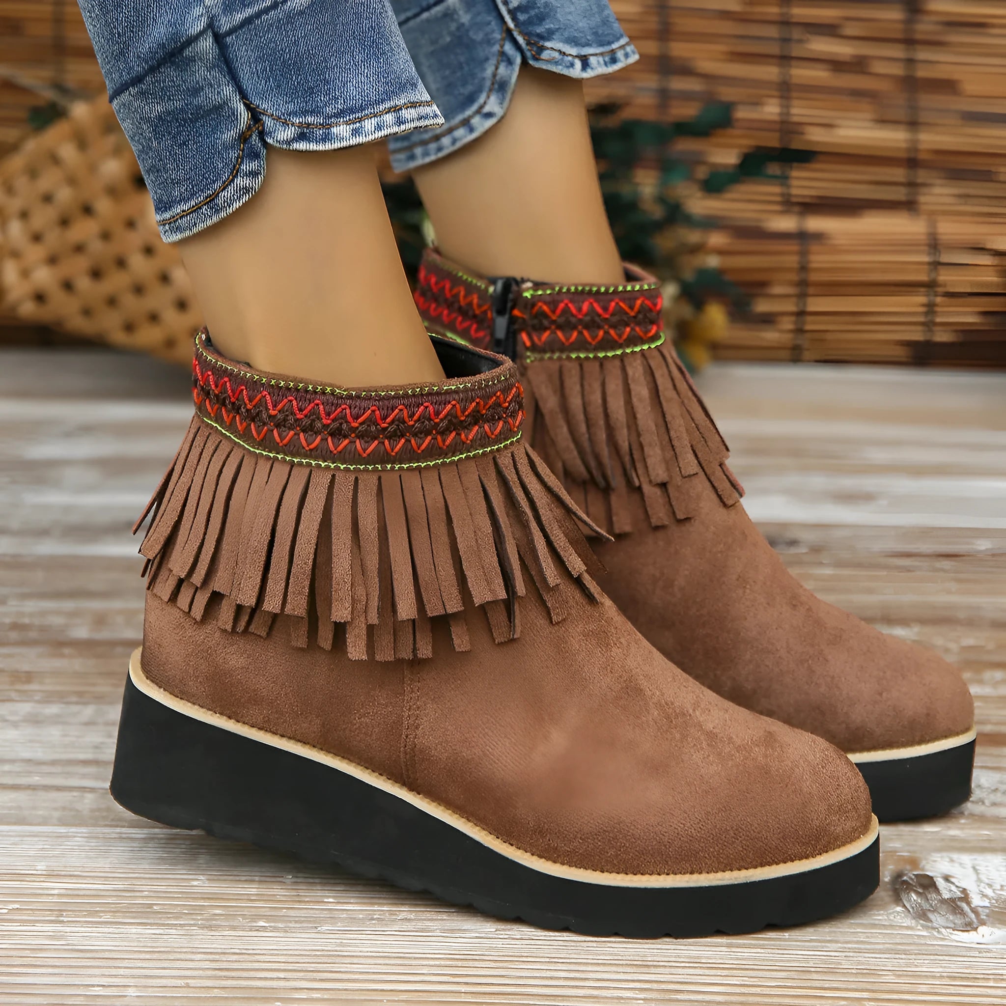 Women's dark brown suede wedge ankle boot with side zipper and tassel detail on a thick rubber sole.