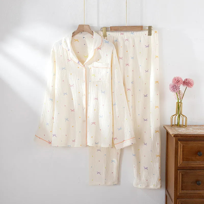 Women's long-sleeved cotton pyjama set in pink, showing top and trousers laid flat
