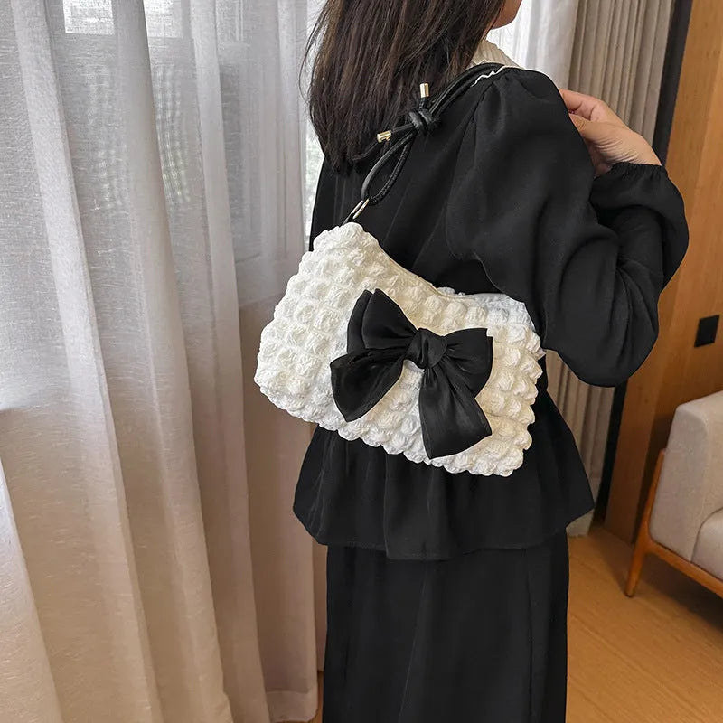 Women's black canvas one-shoulder handbag with a horizontal square shape and single strap