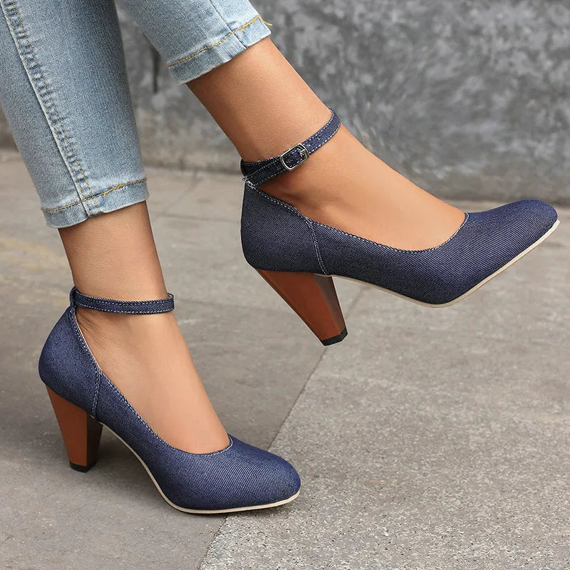 Blue denim women's ankle boots with a buckle strap and thick platform heel on a rubber sole.