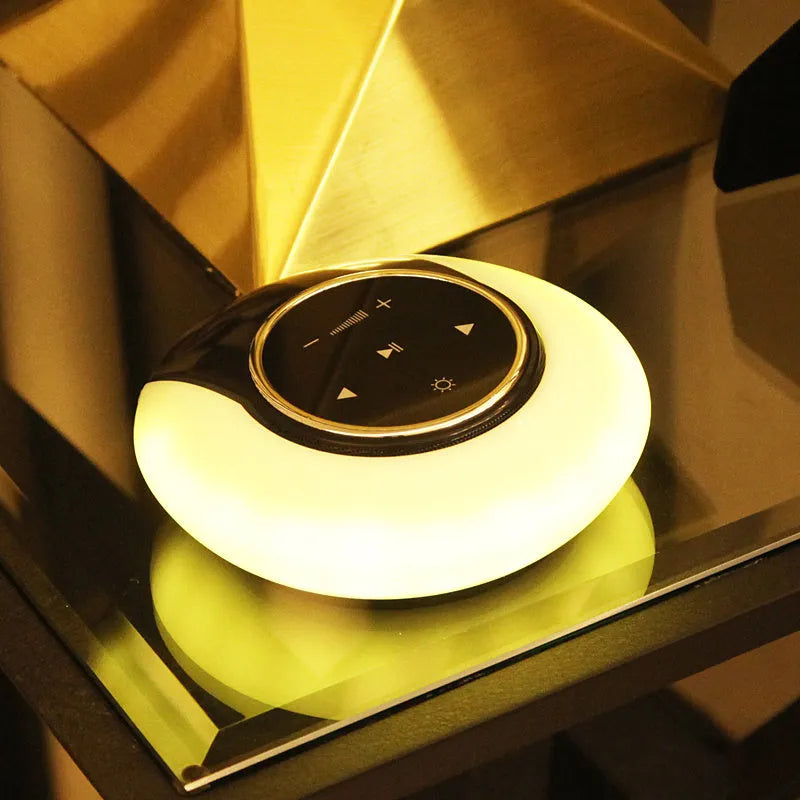 Blue cubic Bluetooth desk lamp speaker with touch controls and folding head on wooden desk