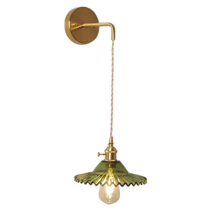 Brass lotus wall lamp with glass shade in six colour options on a wall