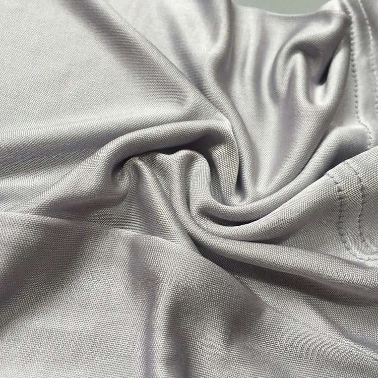 Man wearing loose-fitting mid-waist silk shorts in navy blue, silver grey, or skin colour.