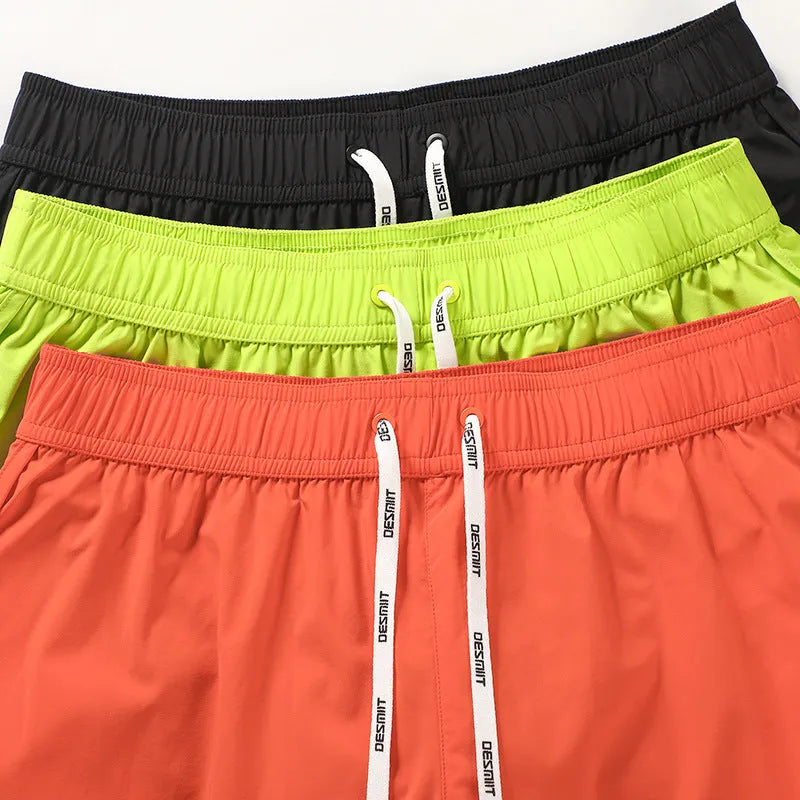 Men's loose orange polyester beach surfing trousers with elasticated fit on a size chart.