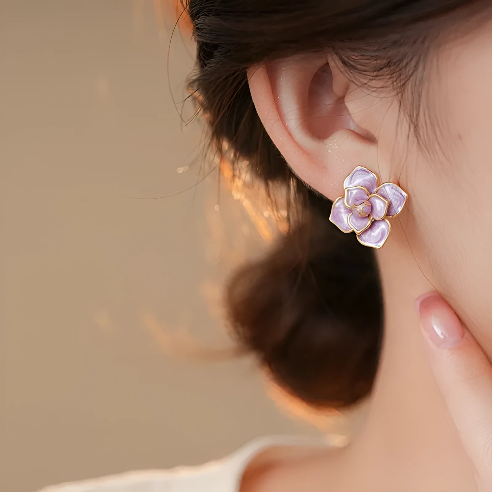 Close-up of gold plated purple oil-spot glaze flower stud earrings on copper base with needle post