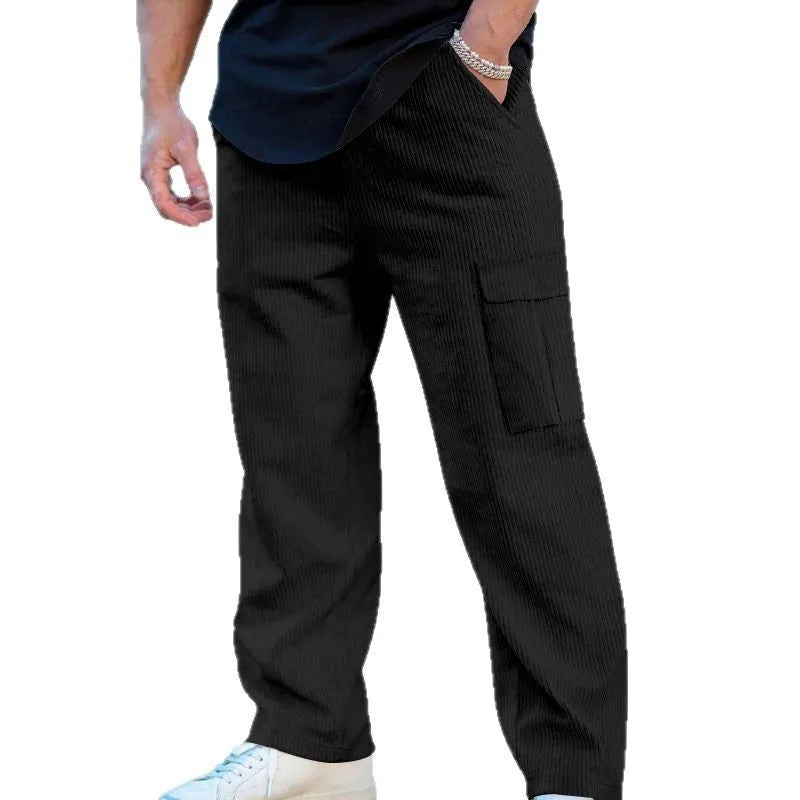 Man wearing navy blue loose-fitting corduroy cargo trousers with a drawstring waist and straight wide legs.