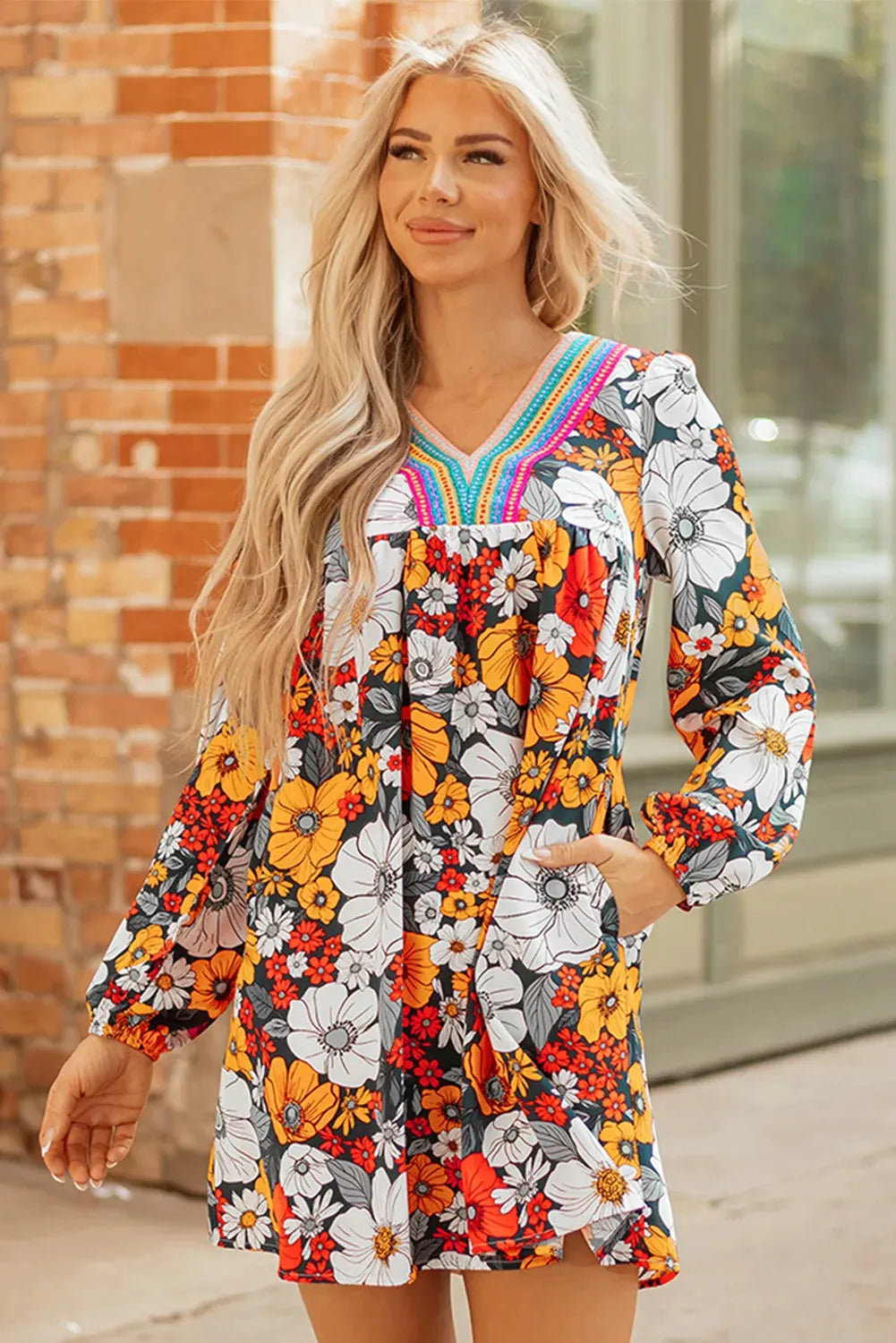 Orange floral and striped print mini dress with lace trim, long sleeves, and a V-neck.