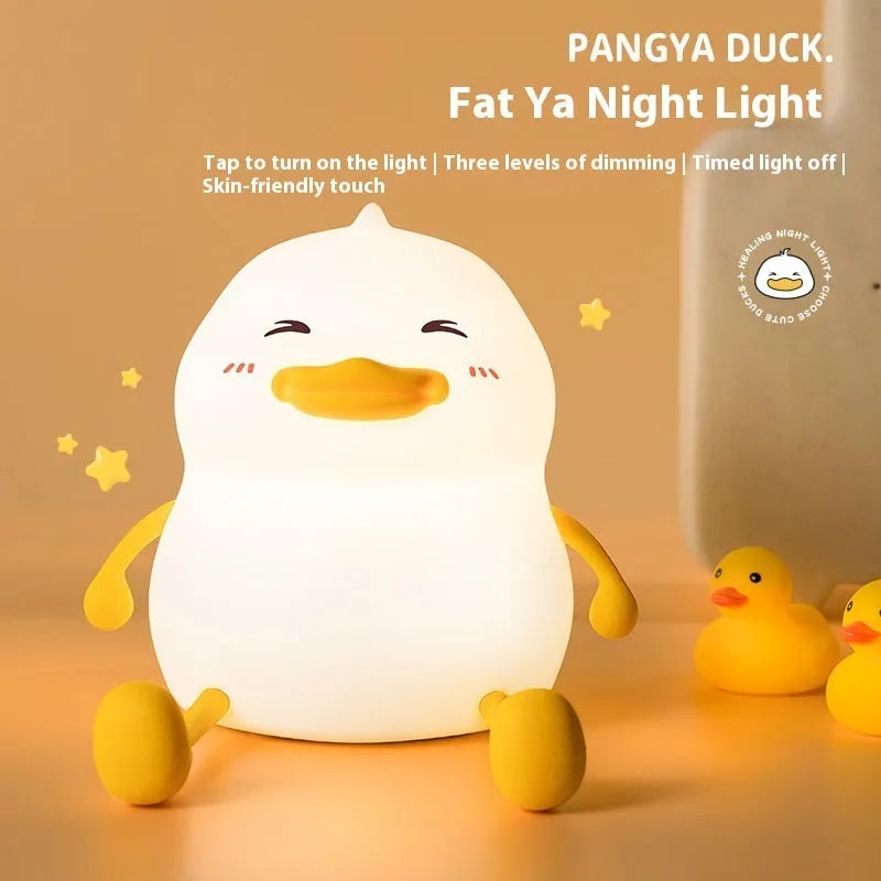 Chubby white USB rechargeable LED night light with built-in silicone phone holder on its base.