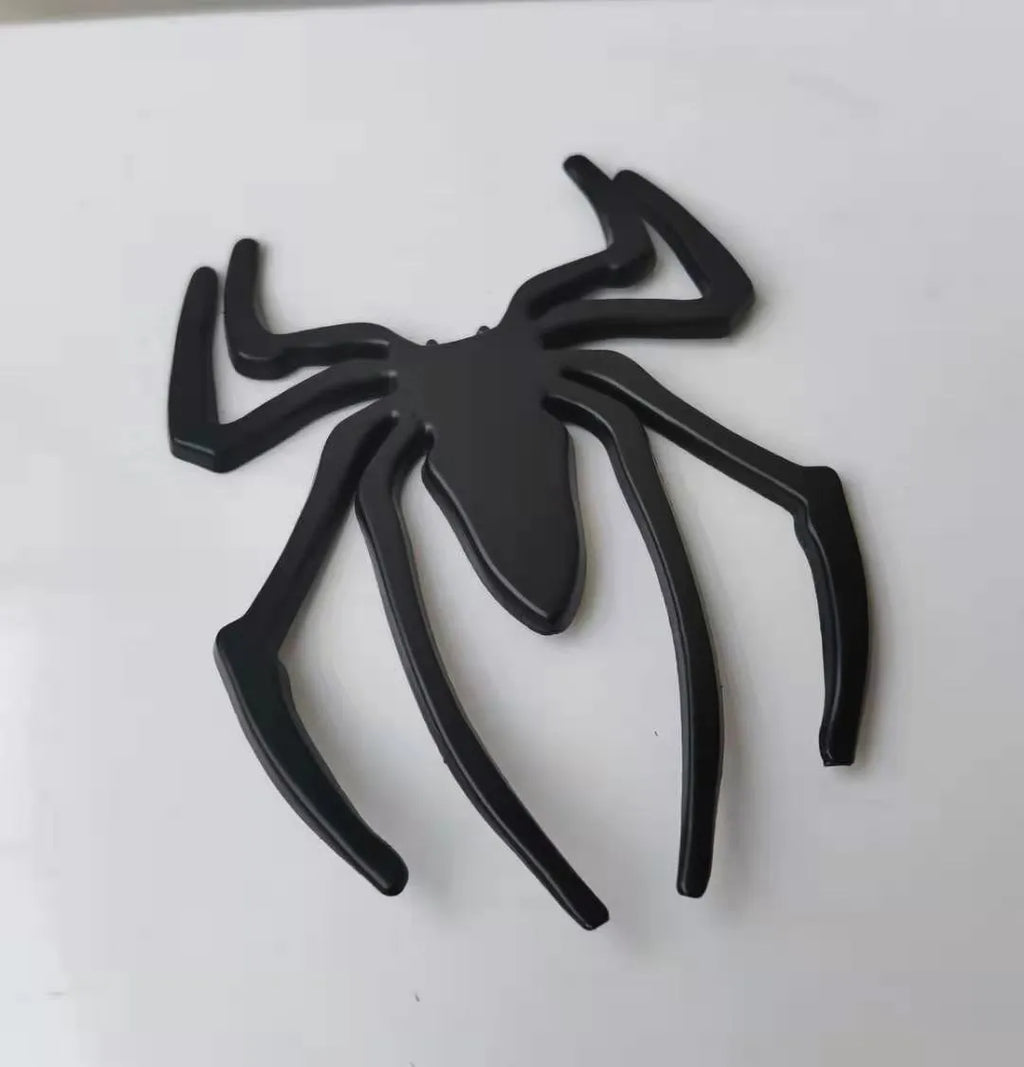Three-dimensional metal spider bumper sticker in zinc alloy, showing gold, silver, black, and red colour options.