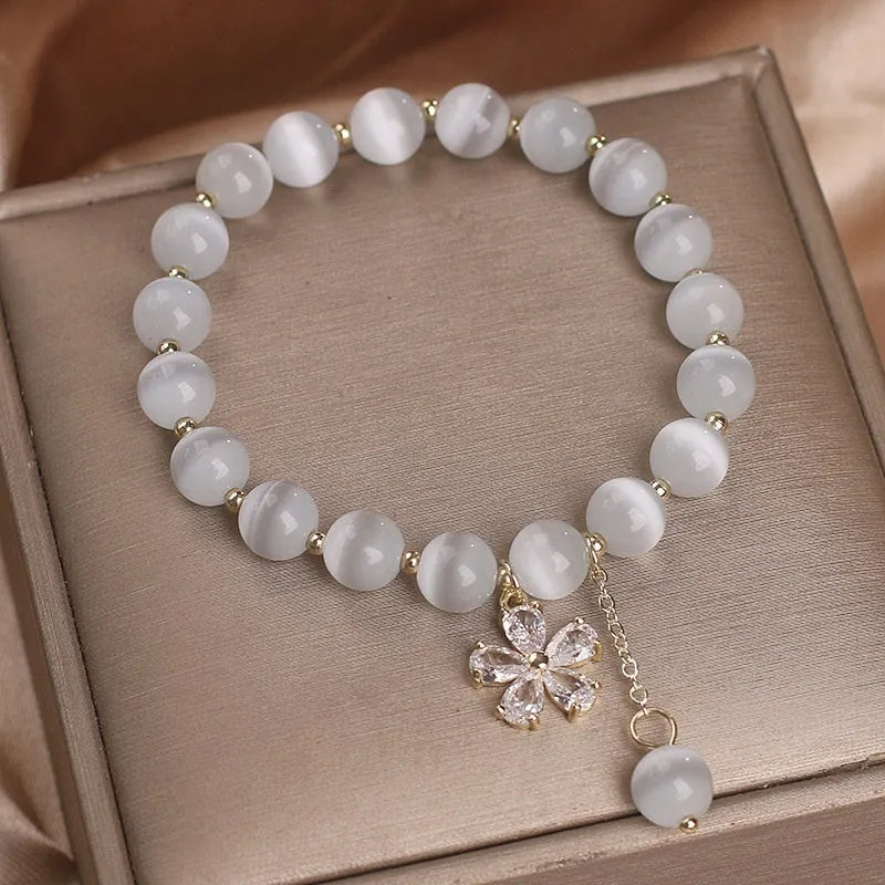 White cat's eye crystal bracelet with flower tassels and morganite safety buckle pendant.