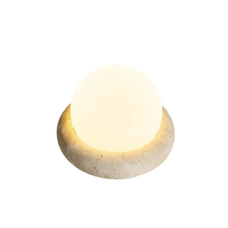 Cream coloured bedside night light with remote control on wooden table