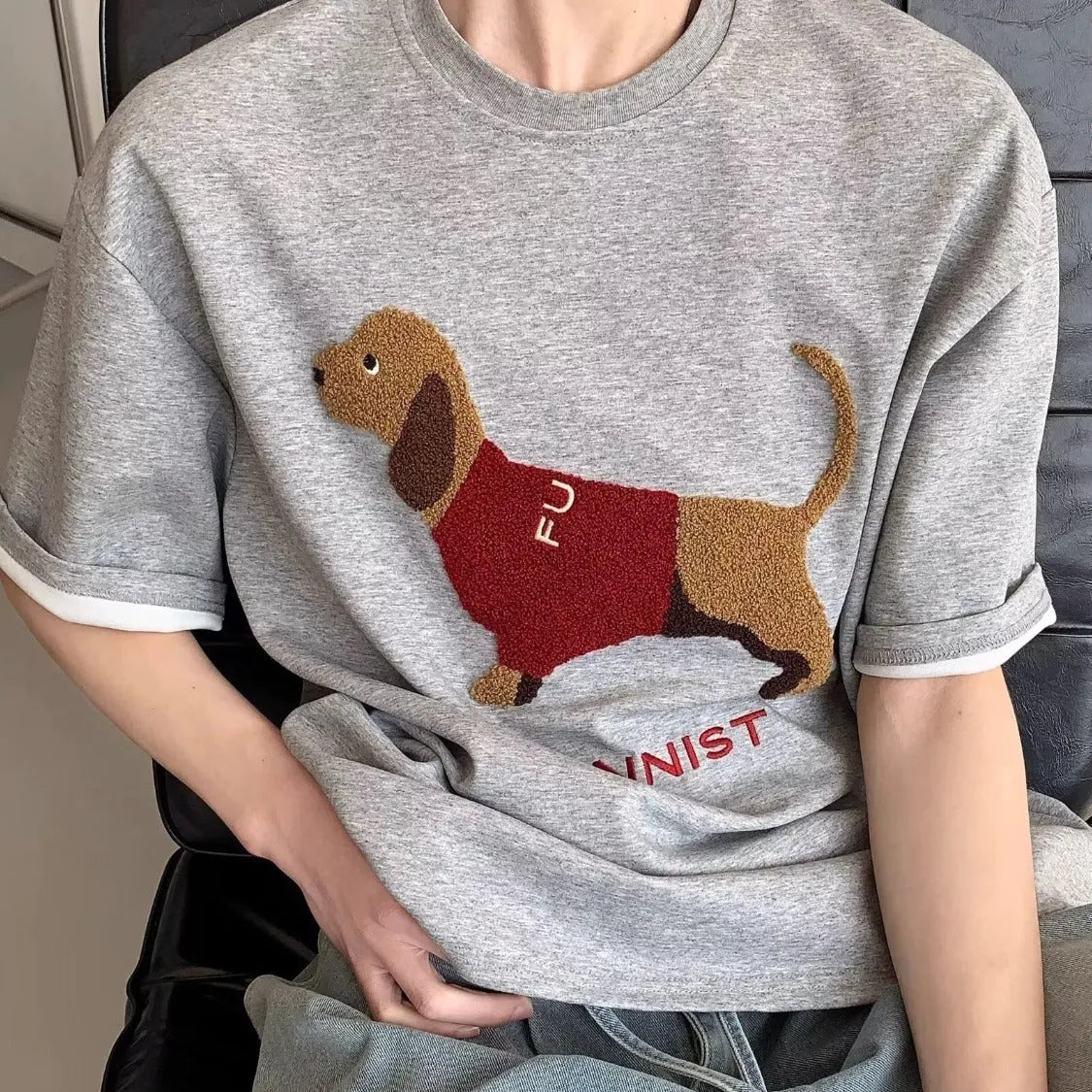 Grey men's round neck T-shirt with an embroidered brown sausage dog design on the front.