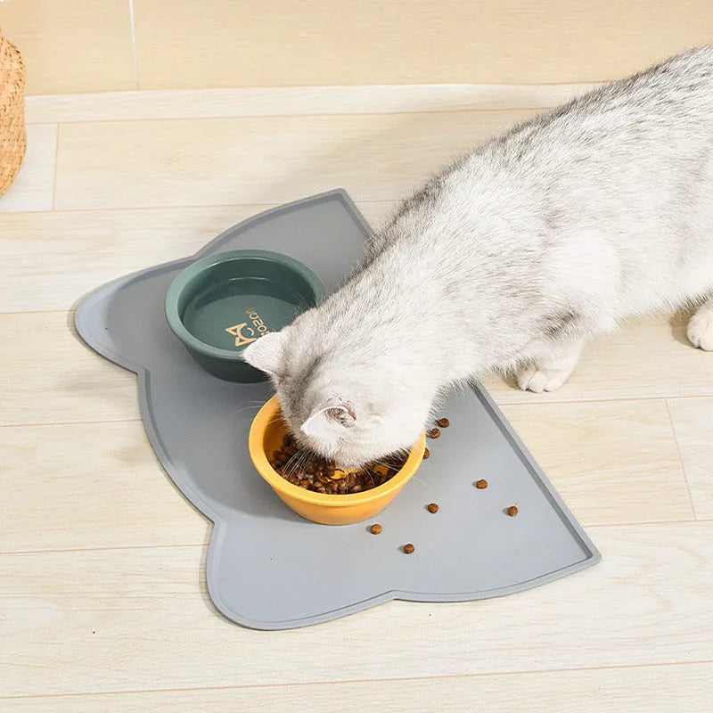 Blue silicone pet feeding mat under food and water bowls measuring 44 by 24 centimetres