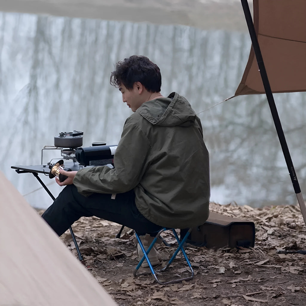 Black ethnic style folding camping stool with aluminium alloy frame, shown in folded and open positions.