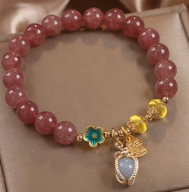 Red women's bracelet with natural strawberry quartz beads, alloy metal chain, and rhinestone details.