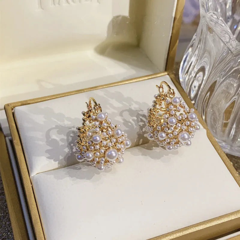 Gold-coloured copper flower basket earrings with rice-shaped bead inlay detail