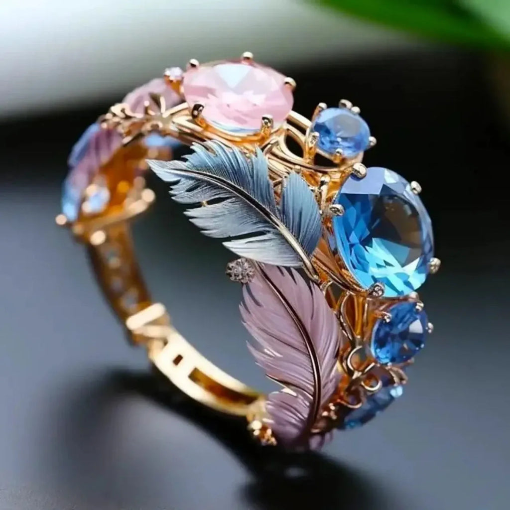 Gold-coloured geometric brass ring with an embossed colourful feather design and zircon inlay.