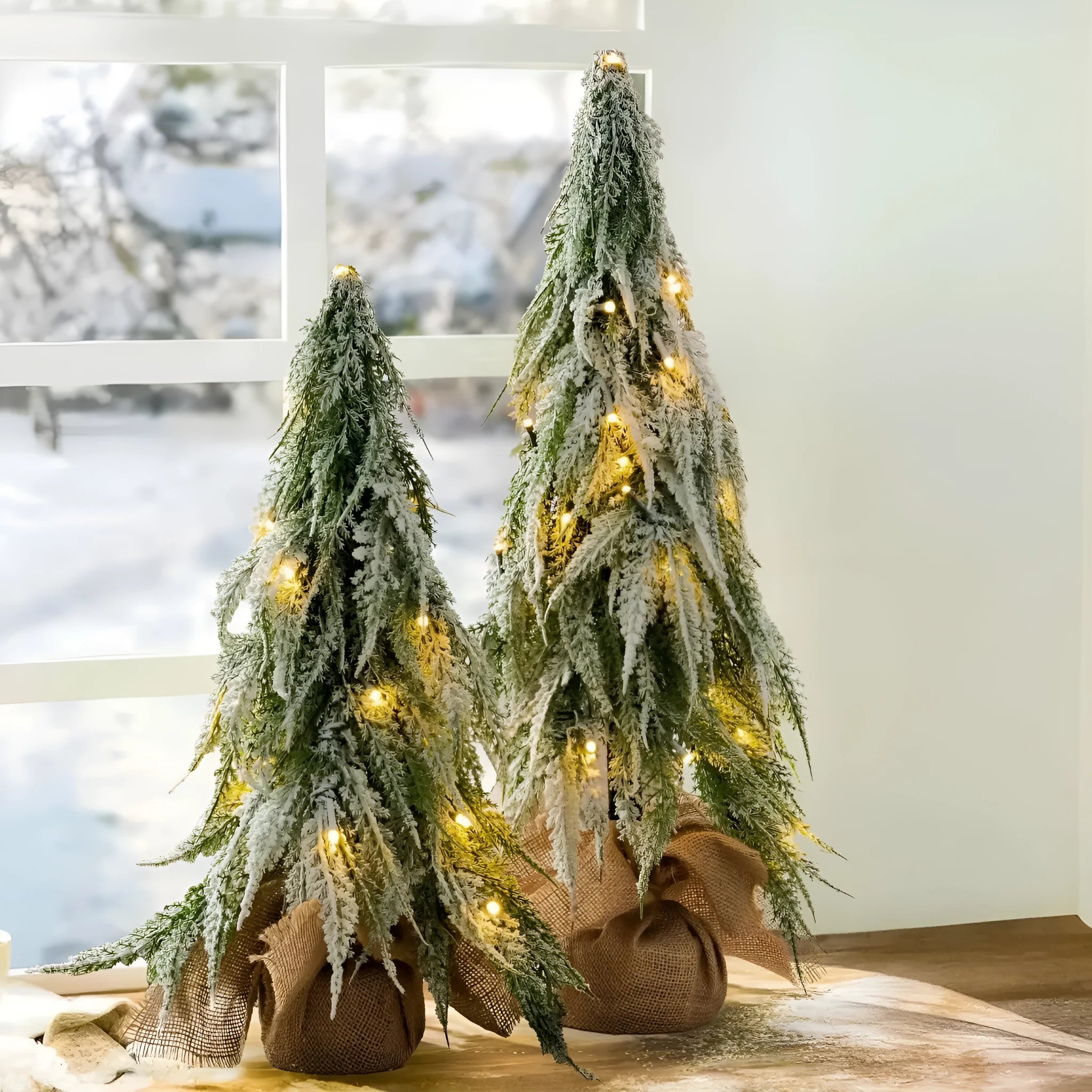Small 24-inch artificial Christmas tree with snow-spray branches and built-in lights for desktop decoration