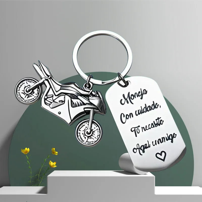 Stainless steel motorcycle keychain with inspirational charm on a flannel bag.