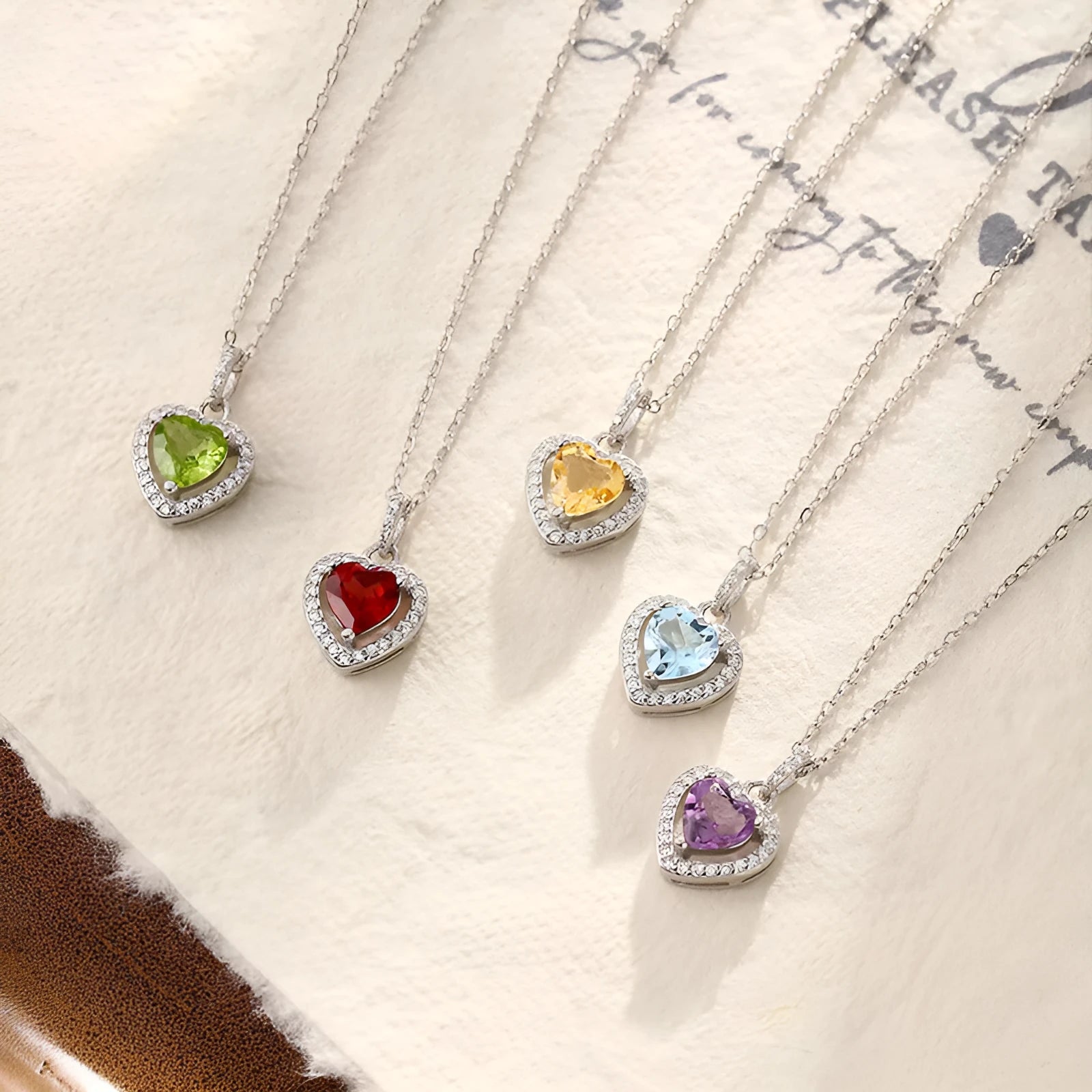 Close-up of a sterling silver heart pendant necklace with an inlaid amethyst gemstone on a cross chain.