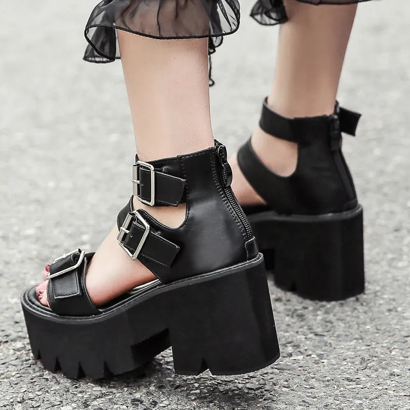 Black women's punk-style chunky heel platform sandals with round toe and buckle detail.