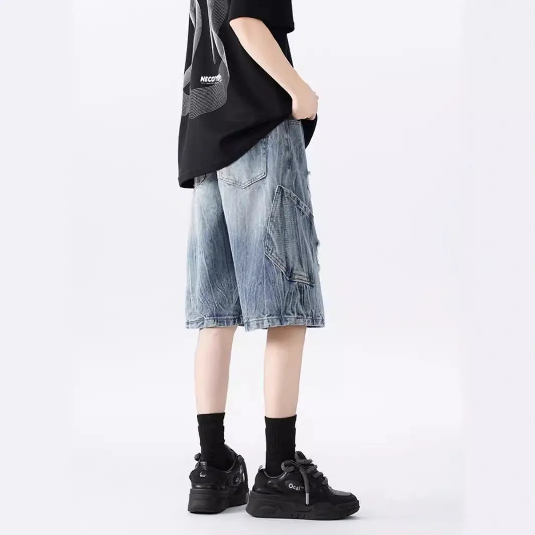 Man's washed blue denim shorts with ripped details and a loose, retro fit.