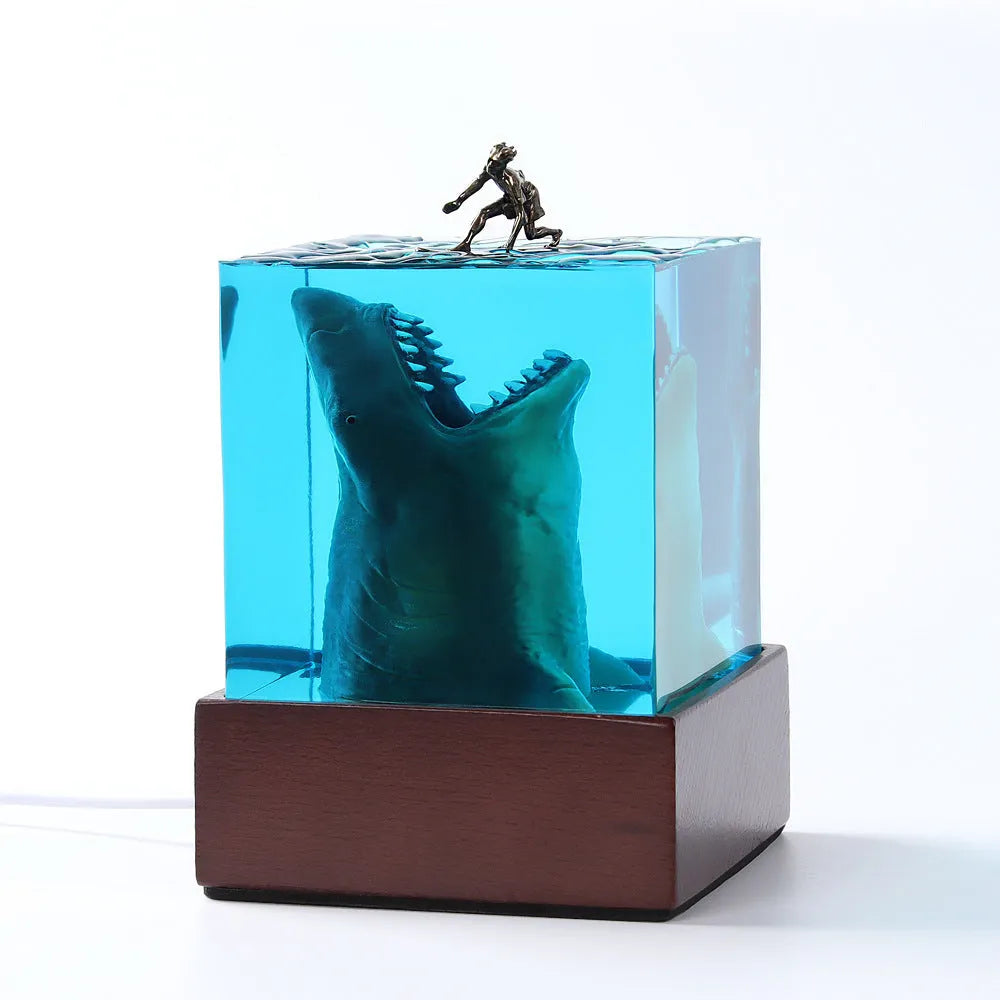 Clear epoxy resin ornament with shark surfing on a wave, includes lamp holder.