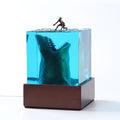 Clear epoxy resin ornament with shark surfing on a wave, includes lamp holder.