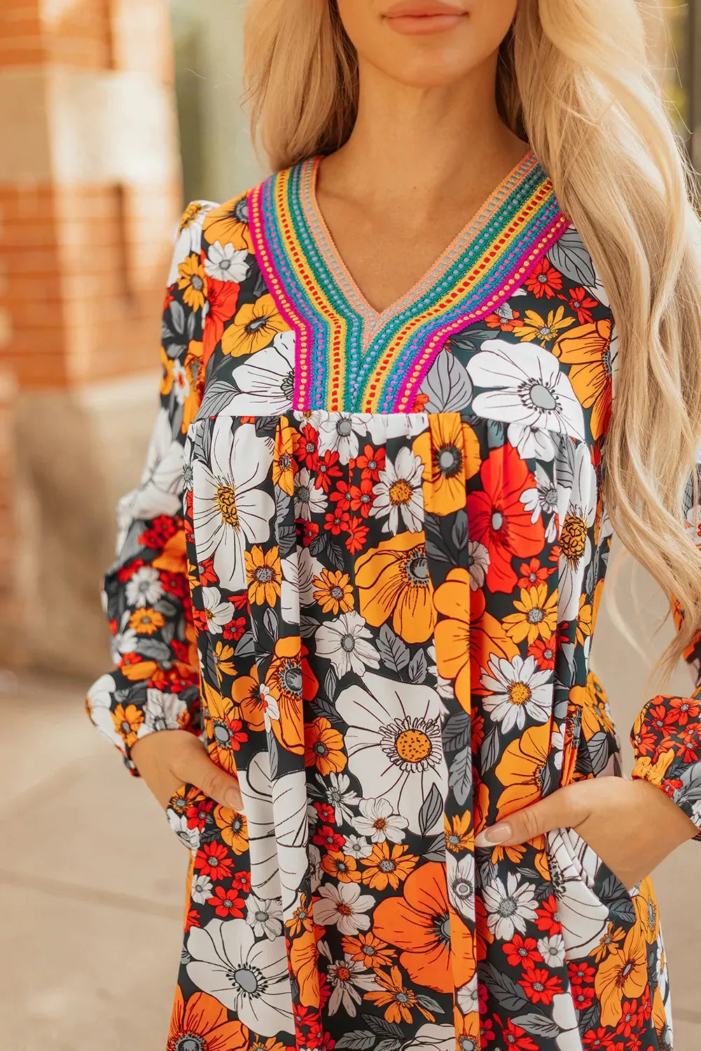 Orange floral and striped print mini dress with lace trim, long sleeves, and a V-neck.