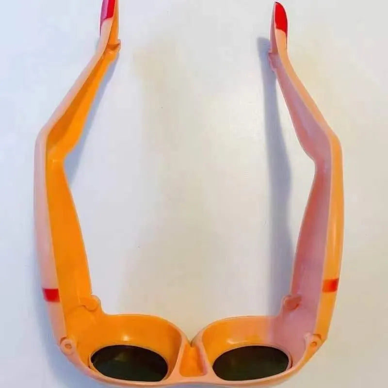 Orange plastic novelty sunglasses with a leg and hip design on the frame
