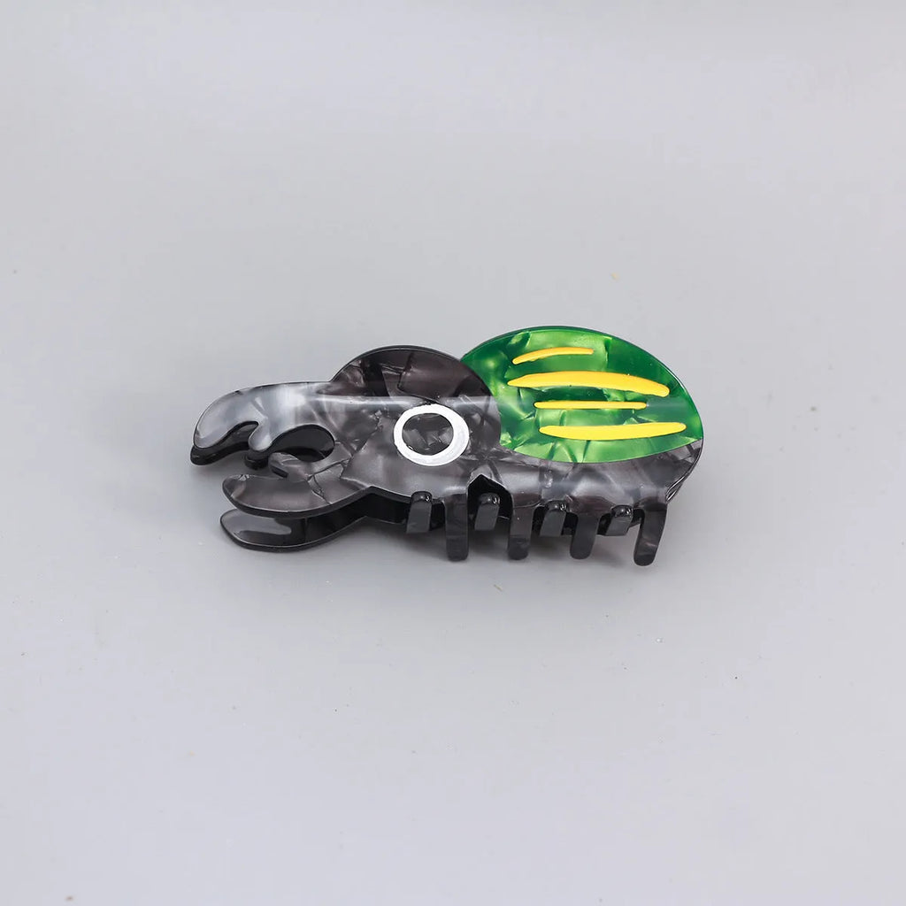 Handmade green and orange beetle grip hair accessory with white cartoon caterpillar design