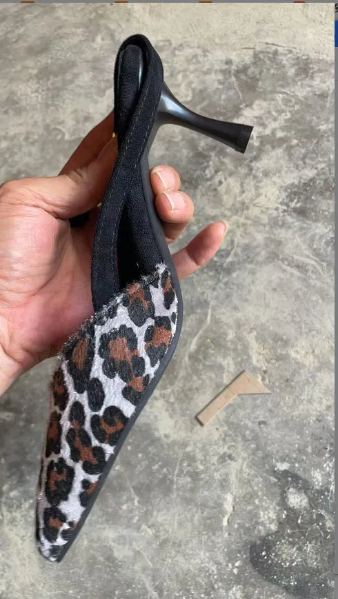 Women's leopard print suede sandals with pointed toe and high heel on size label background.