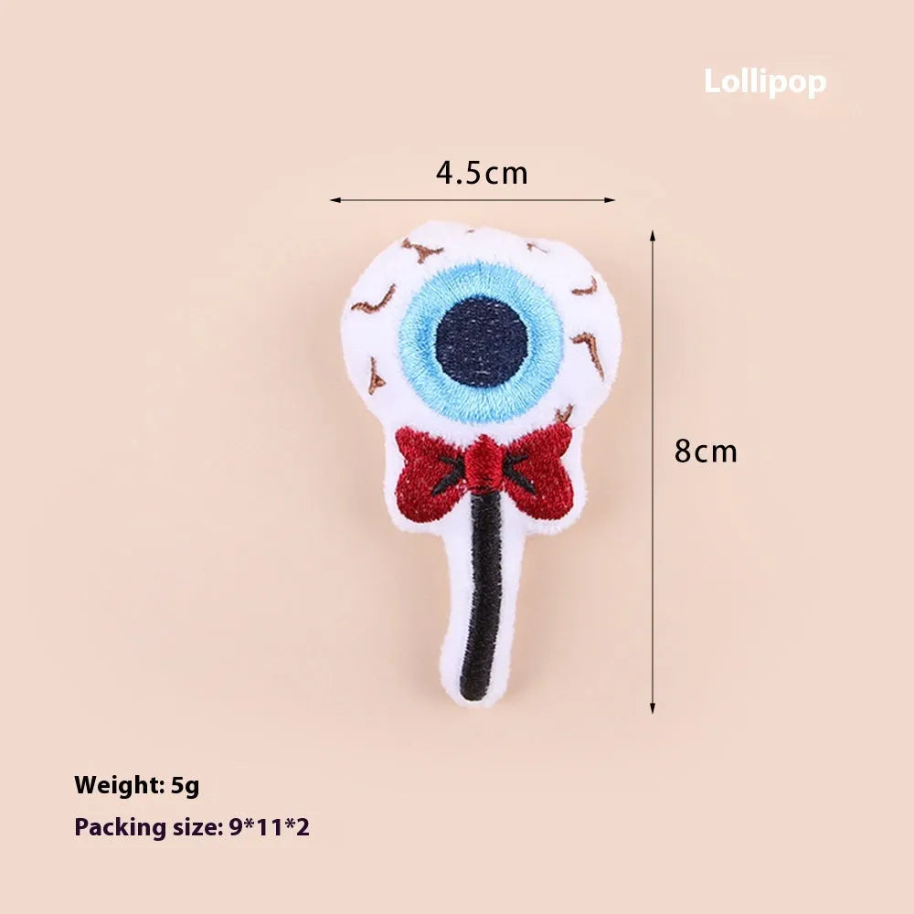 Small plush cat teaser wand toy showing candy, skull and eye patterns on soft fabric