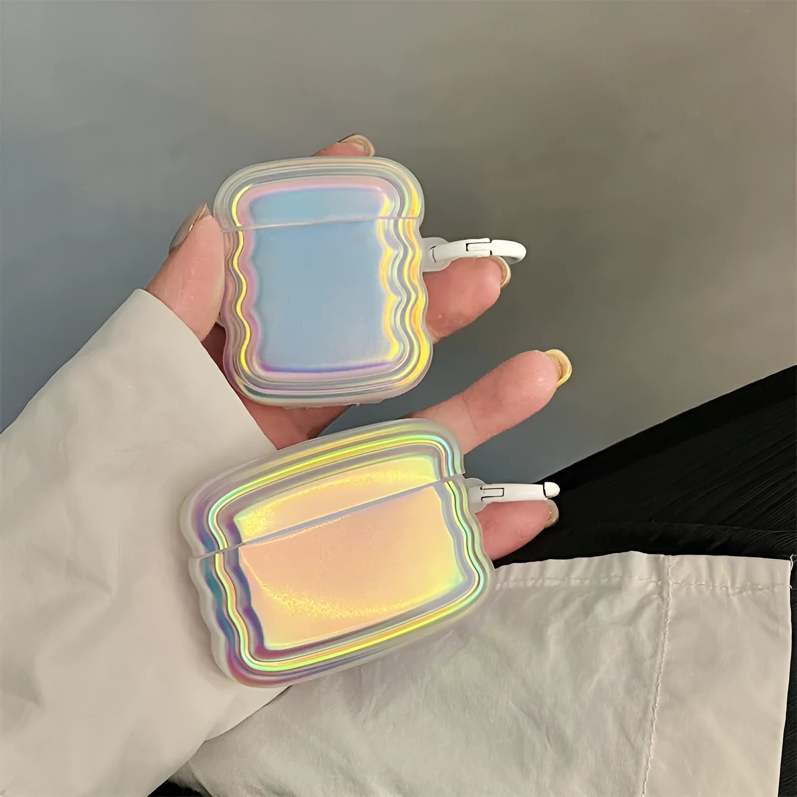 Silicone AirPods case with holographic laser ring design, shown next to AirPods Pro 2 and AirPods 3.