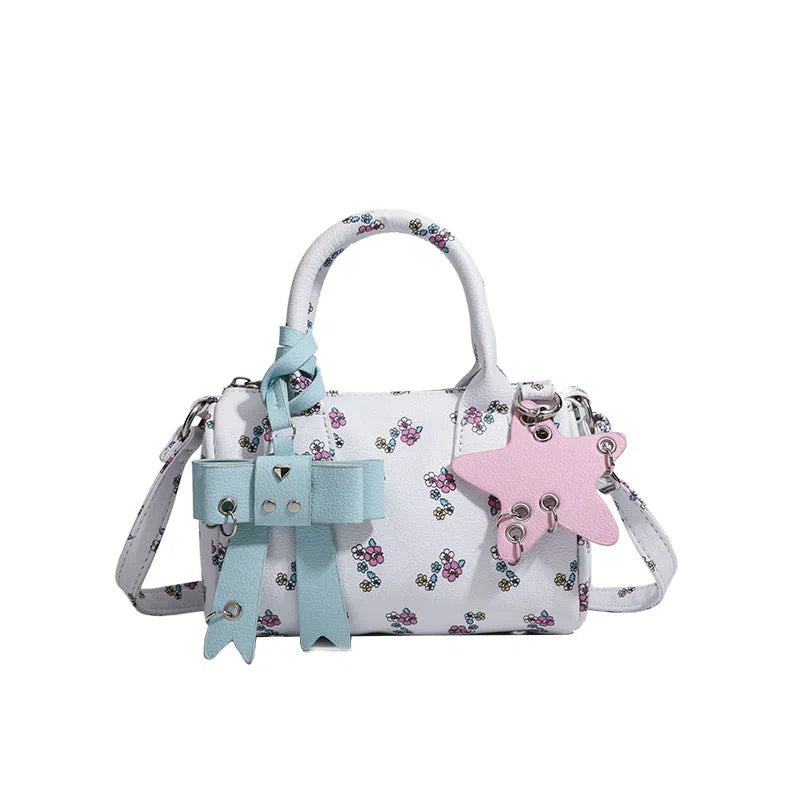 White PU hand-held shoulder bag with petite floral bow accessory on display