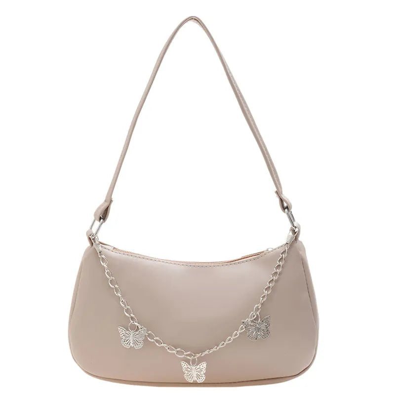 Women's butterfly chain underarm bag in black colour showing crossbody strap and three-dimensional pocket