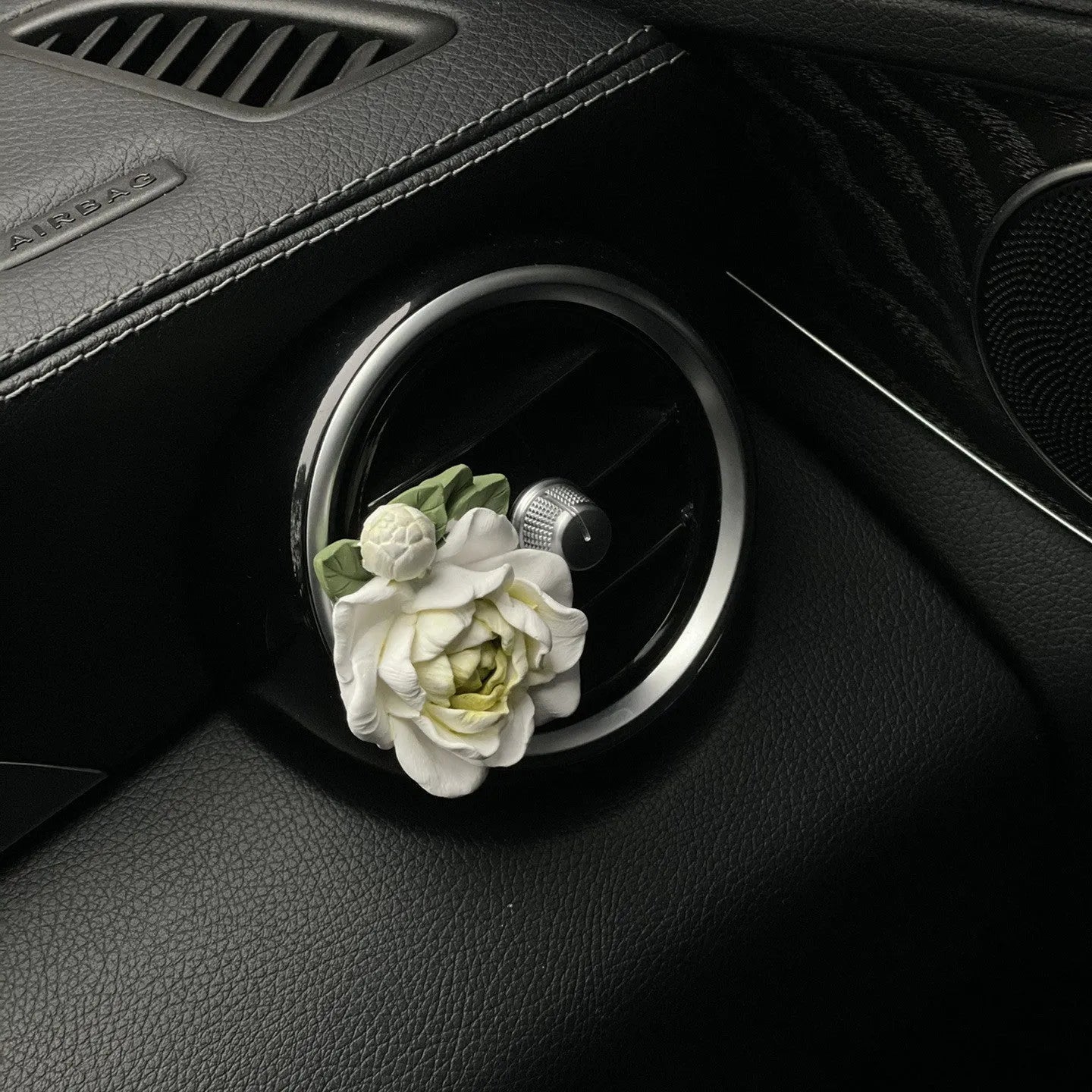 Jasmine solid car perfume gypsum tablet clipped to a car air vent.