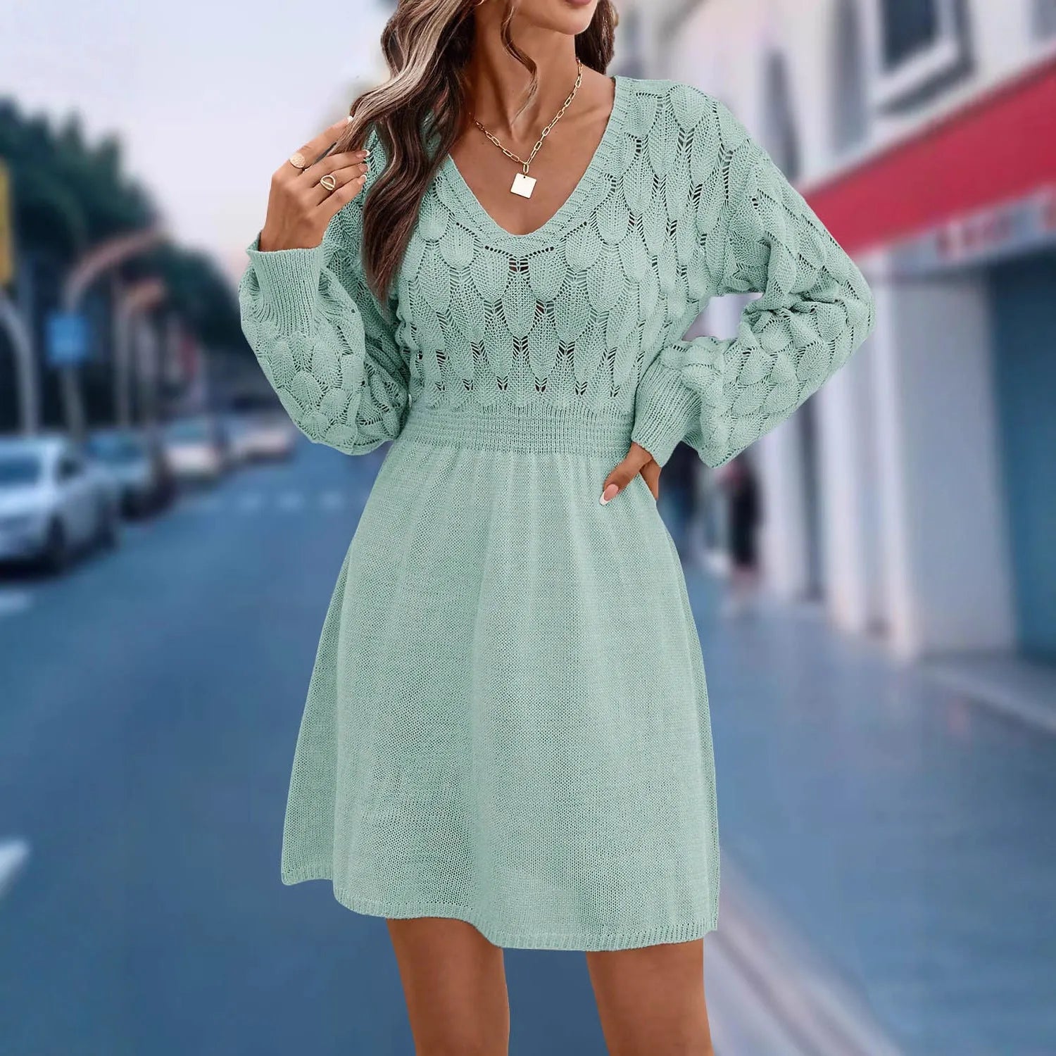 Long sleeve v-neck dress in apricot with artistic 3D pattern details and a high-waisted midi silhouette.