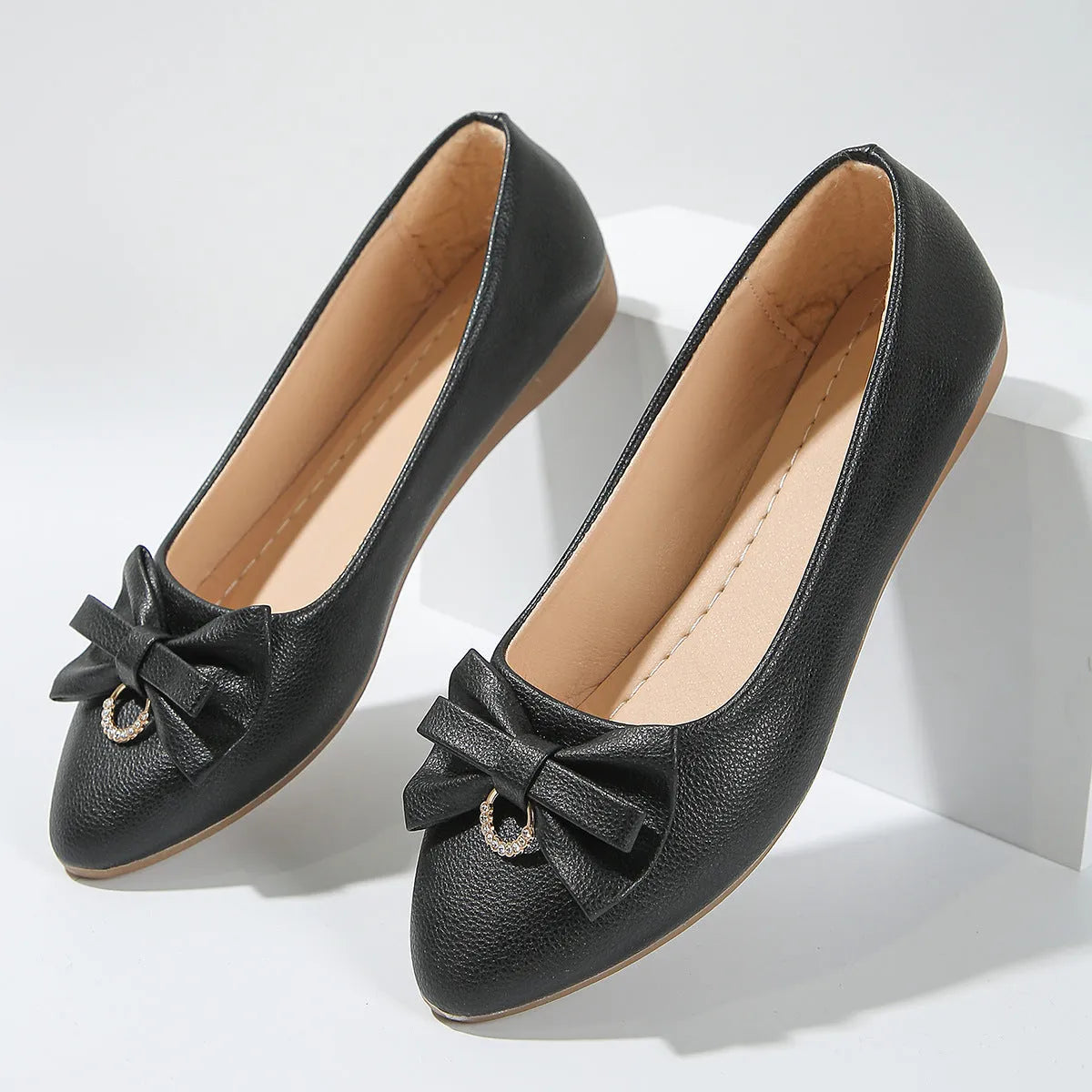 Women's beige casual flat shoes with a bowknot detail and slip-on shallow mouth design.