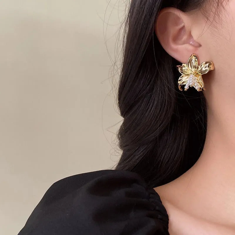 A pair of gold H1795 flower-shaped earrings for women with a Seiko-treated metal finish.
