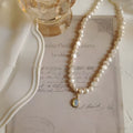 Adjustable French court vintage style pearl necklace with geometric design on a model.
