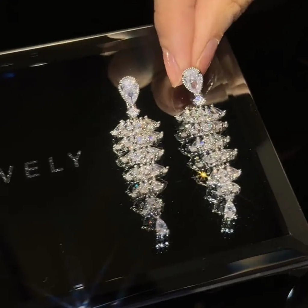 Women's silver pagoda Christmas tree drop earrings with a dangling zircon star on copper studs.