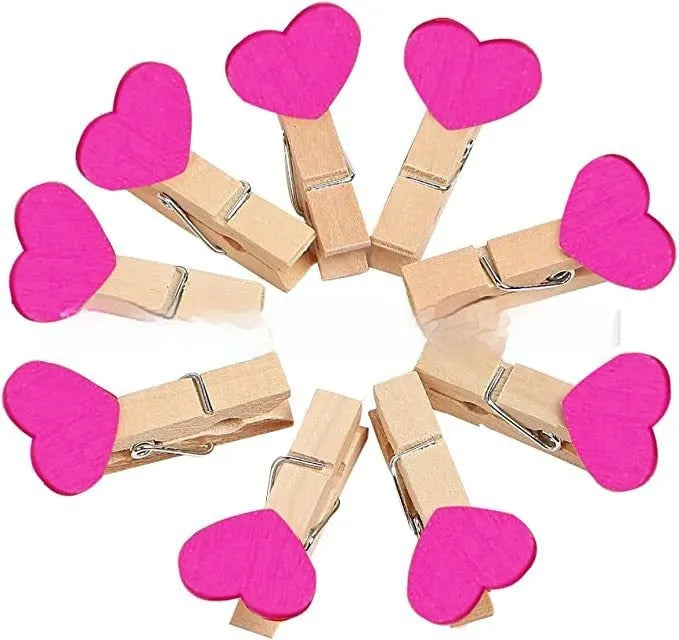 Set of five handmade solid wood heart-shaped clips in red, white, and rose red on a wooden surface.