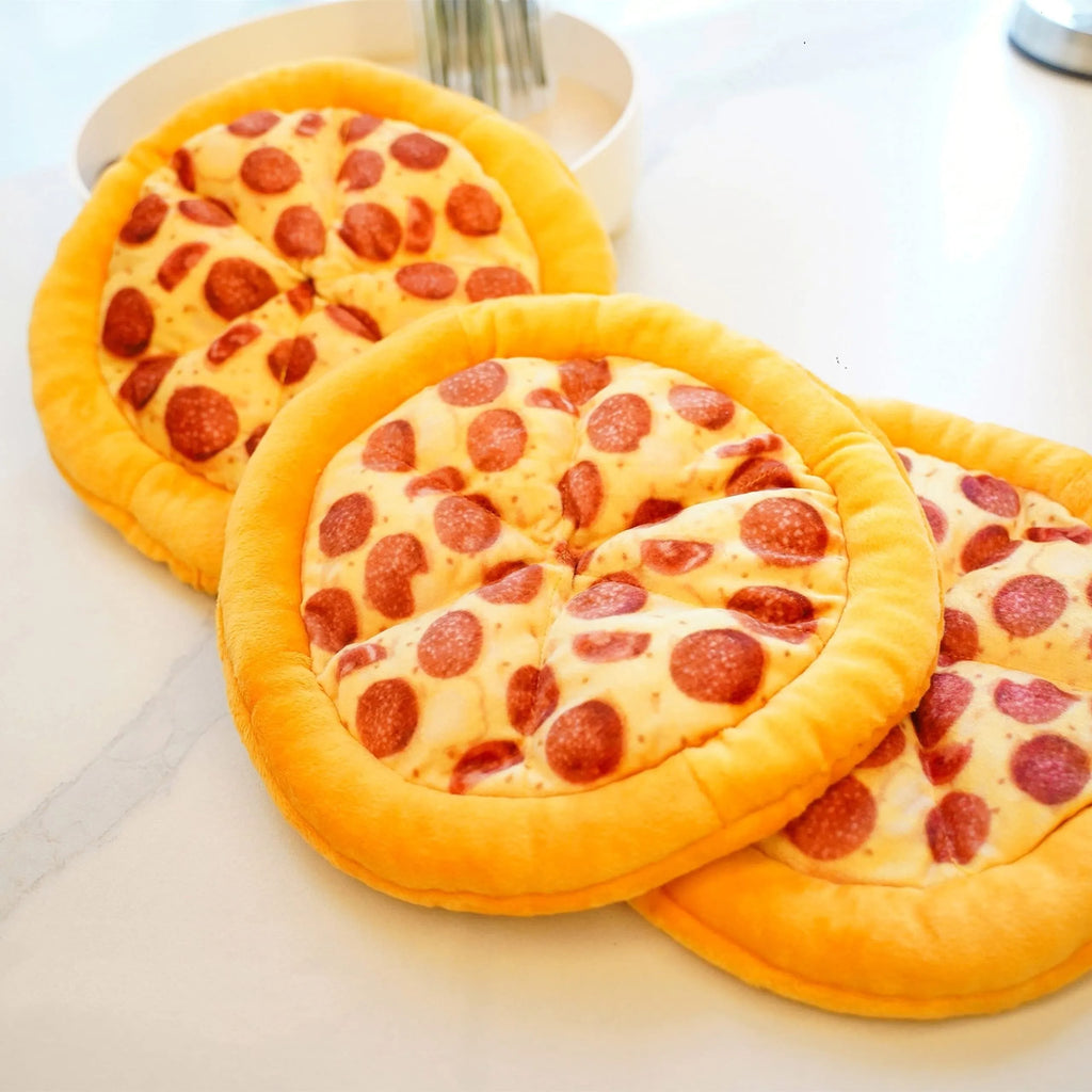 Yellow pizza slice shaped plush squeaky dog chew toy on a white background