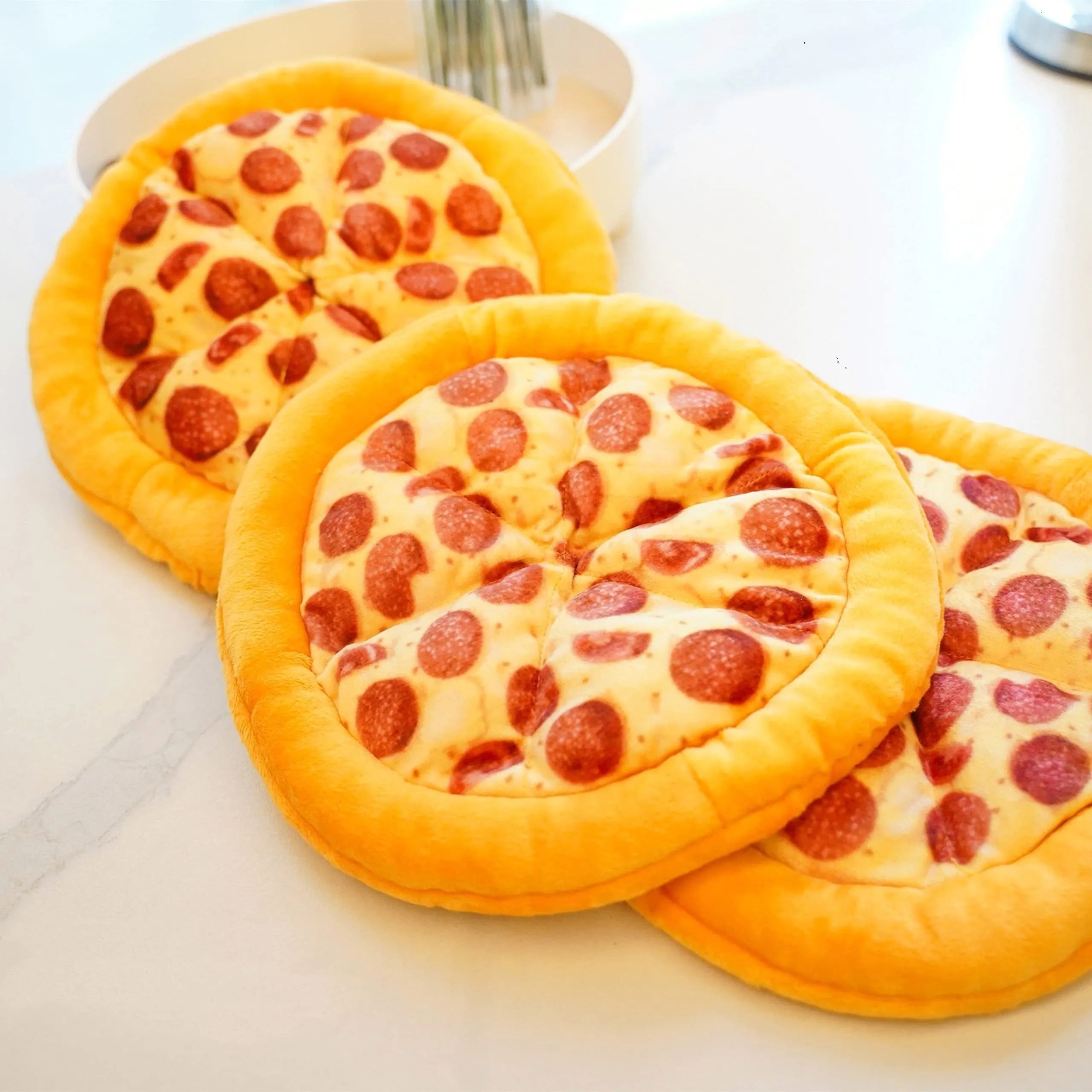 Yellow pizza slice shaped plush squeaky dog chew toy on a white background