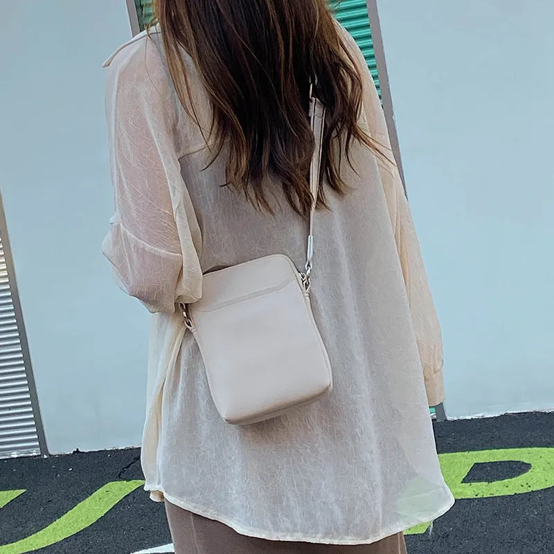 Black PU mobile phone bag with crossbody strap showing shoulder carry option