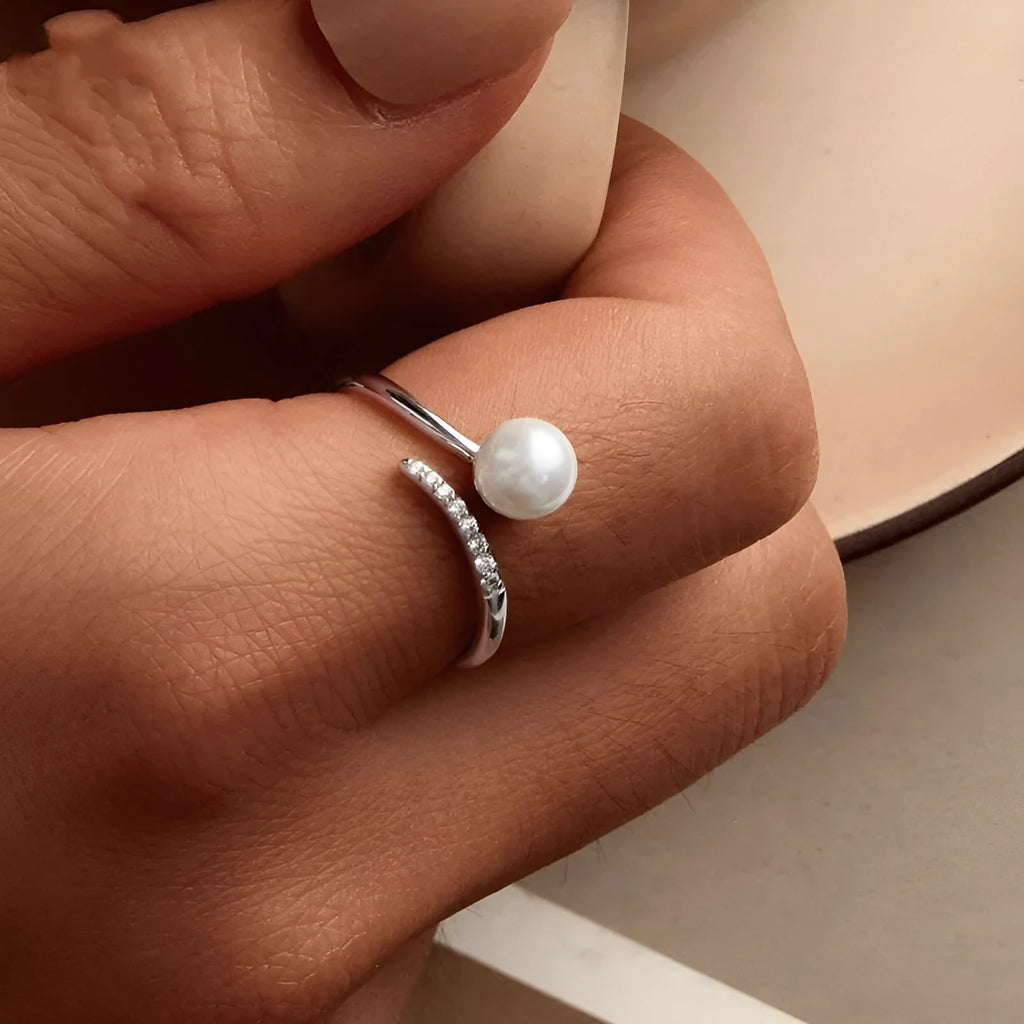 Women's adjustable sterling silver ring with a natural shell pearl on an opening loop band.