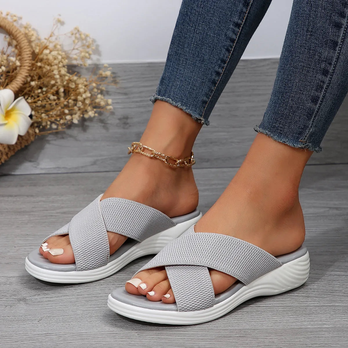 Black women's wedge slipper with a cross strap and open peep-toe on a thick rubber sole.