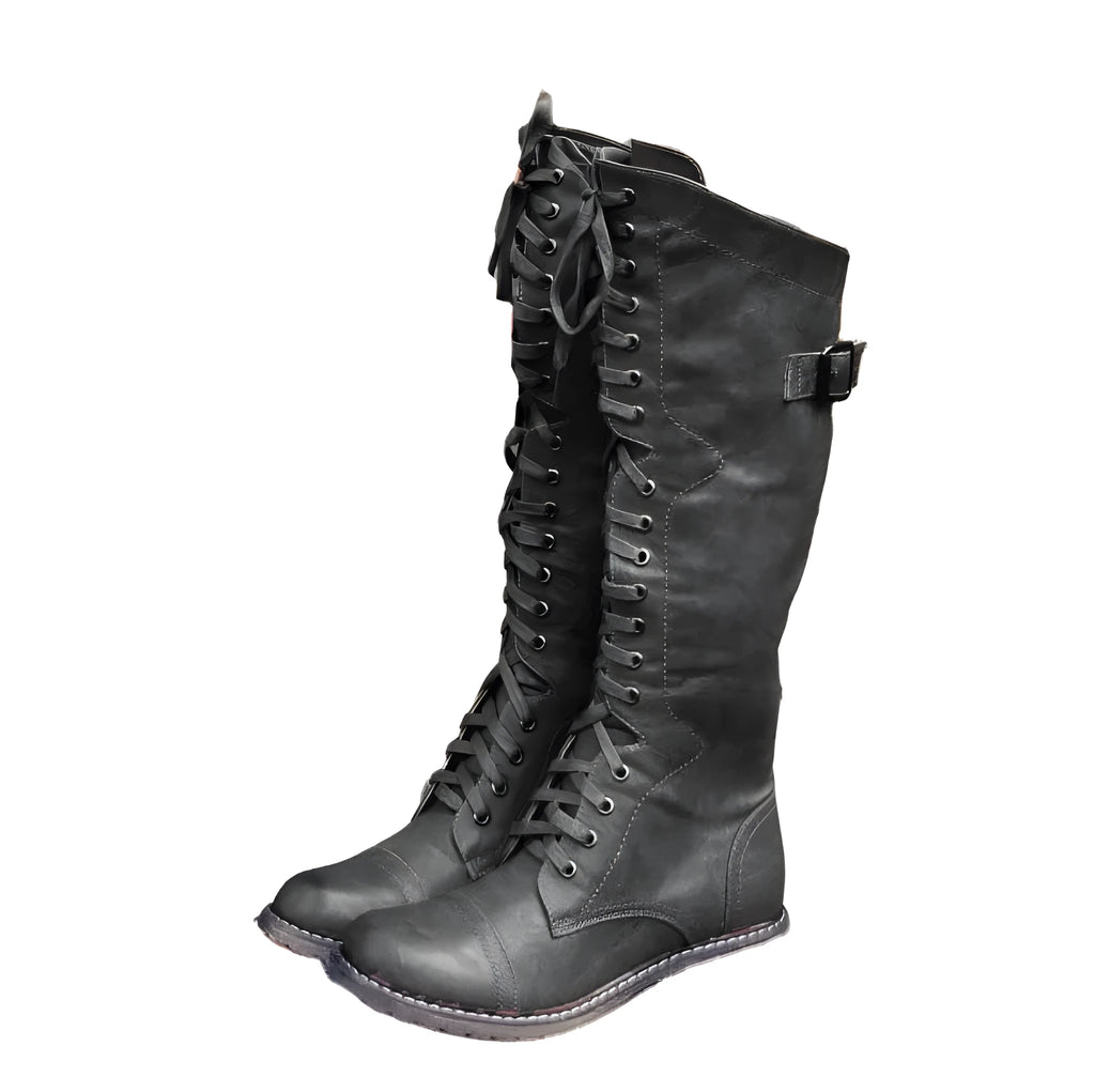 Women's black artificial PU knight boots with cross strap detail on ankle.